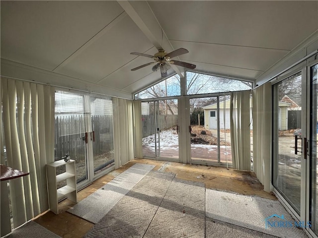 unfurnished sunroom featuring ceiling fan, lofted ceiling with beams, and a healthy amount of sunlight