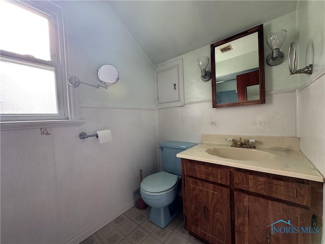 bathroom with vanity, lofted ceiling, and toilet