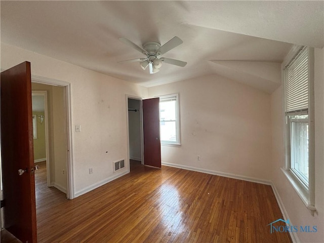 unfurnished bedroom with lofted ceiling, dark wood-type flooring, and ceiling fan