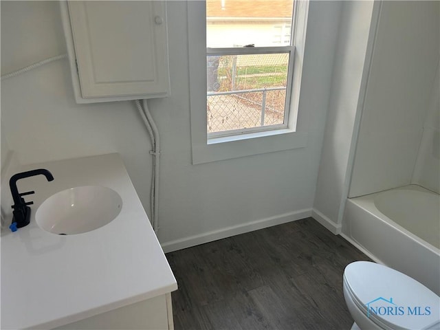 full bathroom featuring shower / tub combination, vanity, hardwood / wood-style floors, and toilet