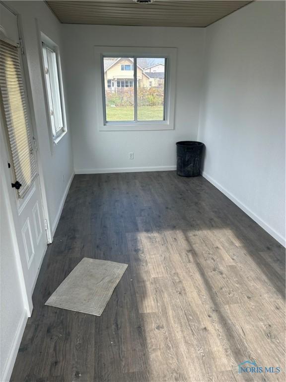 unfurnished room with dark hardwood / wood-style flooring