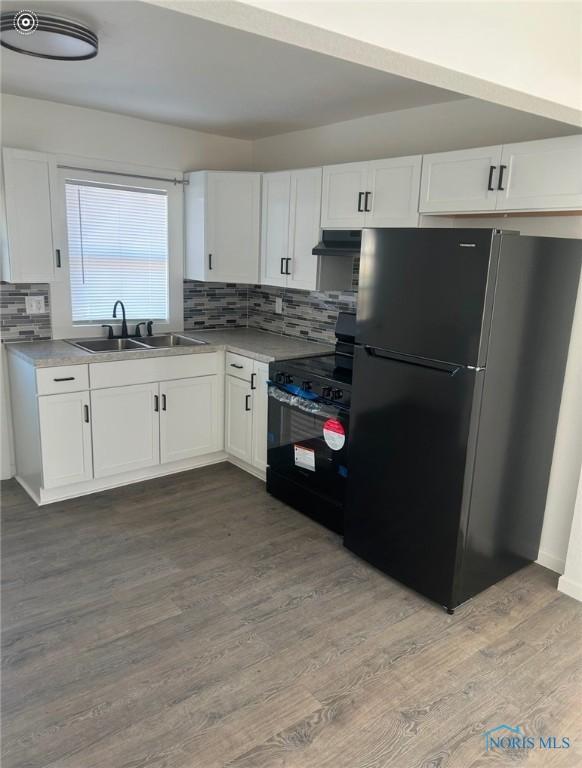 kitchen with sink, light hardwood / wood-style flooring, white cabinetry, black appliances, and decorative backsplash