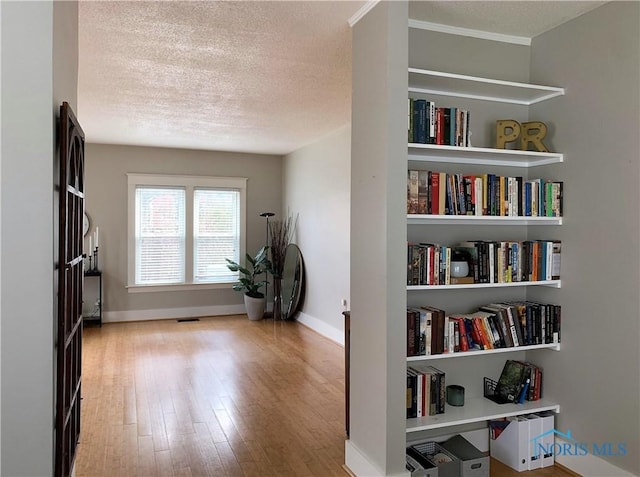 interior space with a textured ceiling and light hardwood / wood-style floors