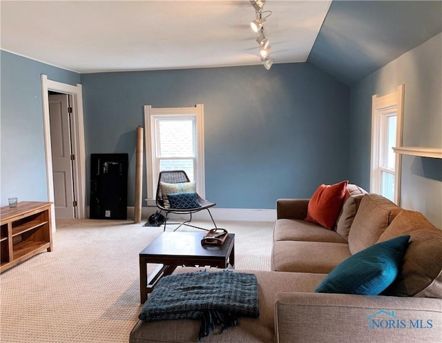 carpeted living room featuring vaulted ceiling and track lighting