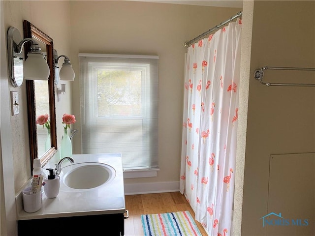 bathroom with a shower with shower curtain, vanity, and hardwood / wood-style flooring