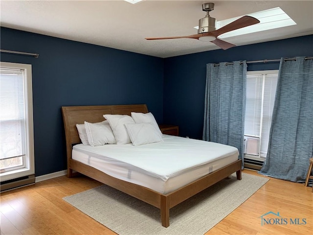 bedroom featuring multiple windows, ceiling fan, and hardwood / wood-style flooring