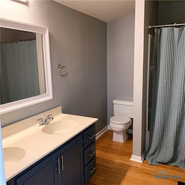 bathroom featuring a shower with curtain, vanity, toilet, and wood-type flooring