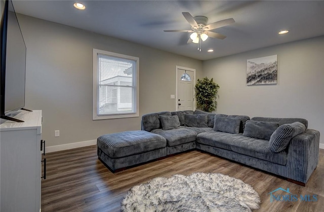 living room featuring ceiling fan and dark wood-type flooring