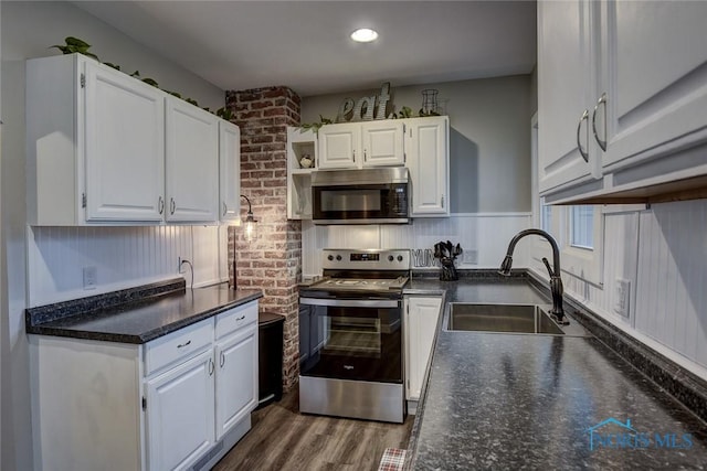 kitchen with white cabinets, sink, stainless steel range with electric cooktop, and dark wood-type flooring