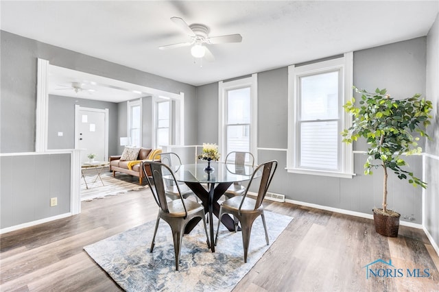 dining area with a wealth of natural light, ceiling fan, and wood-type flooring