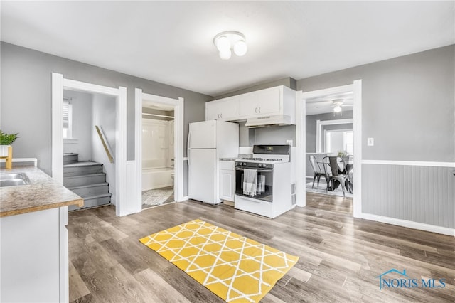 kitchen with white appliances, ceiling fan, sink, light hardwood / wood-style flooring, and white cabinets