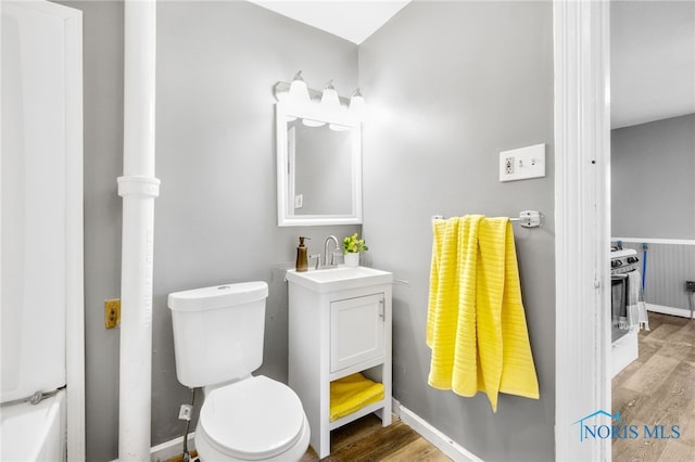 bathroom featuring wood-type flooring, vanity, and toilet