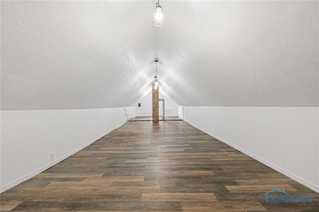 bonus room with a textured ceiling, lofted ceiling, and dark hardwood / wood-style floors