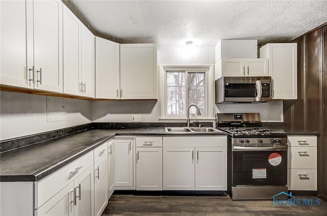 kitchen featuring white cabinets, a textured ceiling, stainless steel appliances, and sink