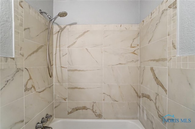 bathroom featuring tiled shower / bath