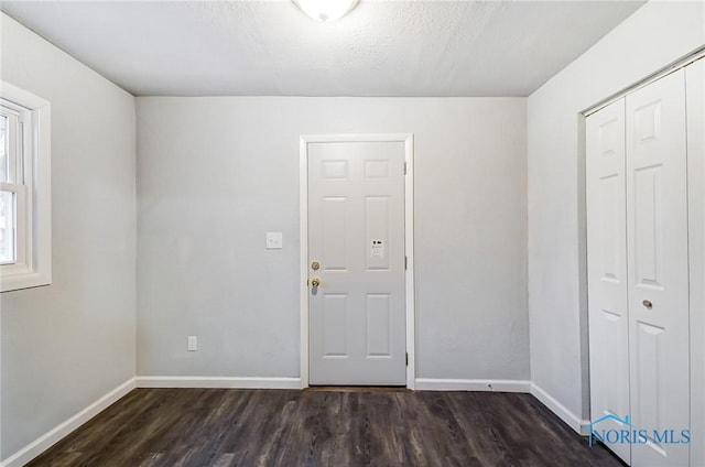 interior space featuring dark hardwood / wood-style flooring and a textured ceiling