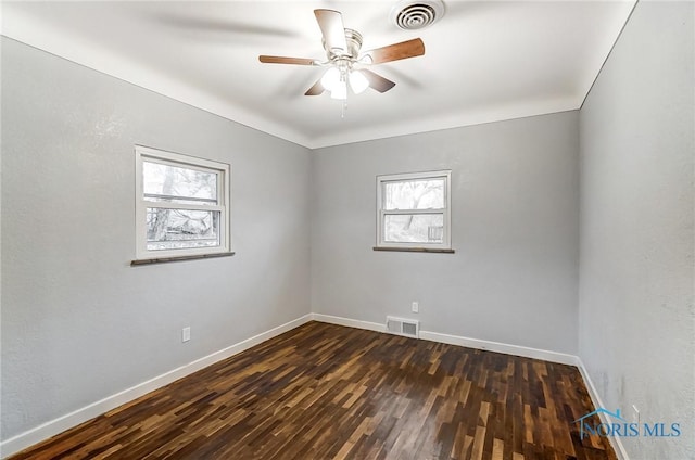 empty room with ceiling fan and dark wood-type flooring