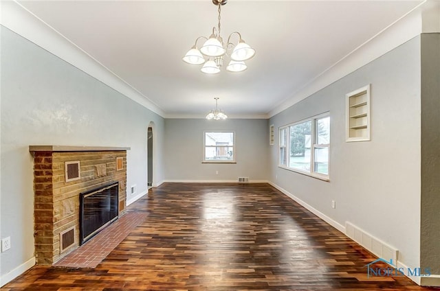 unfurnished living room featuring a notable chandelier, dark hardwood / wood-style floors, built in features, and ornamental molding