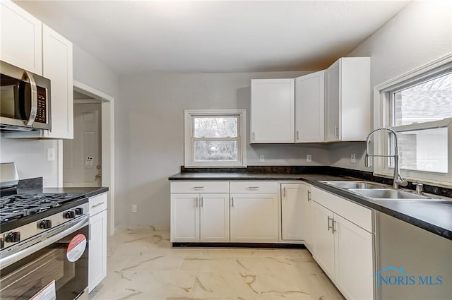 kitchen featuring sink, white cabinets, plenty of natural light, and appliances with stainless steel finishes