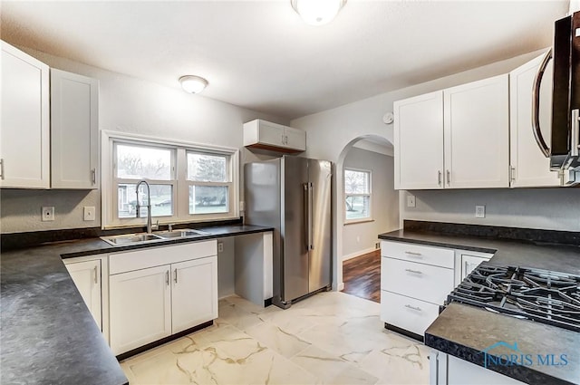 kitchen with high end fridge, white cabinetry, and sink