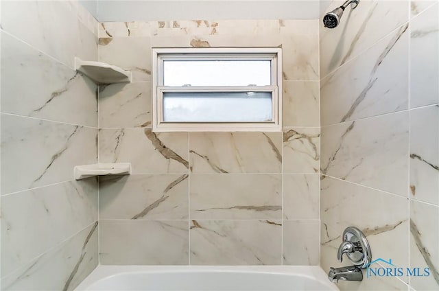 bathroom featuring tiled shower / bath