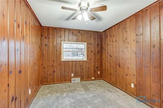 carpeted empty room with ceiling fan and crown molding