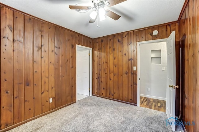 carpeted spare room featuring ceiling fan and ornamental molding