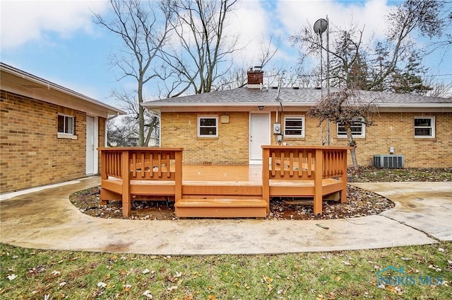 rear view of property featuring a wooden deck and a patio