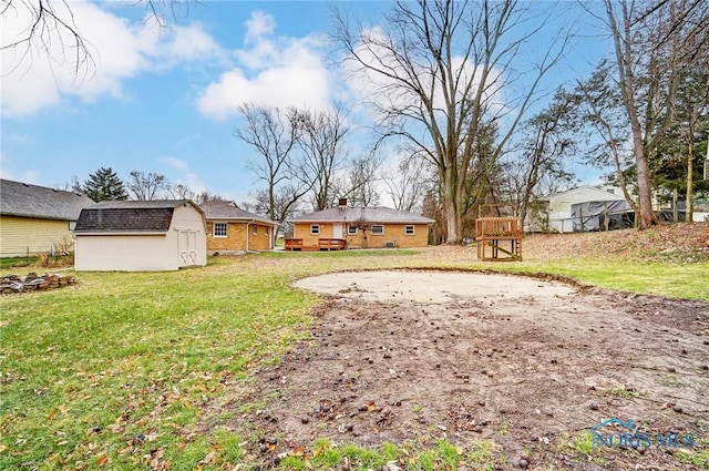 view of yard featuring a deck and a storage unit