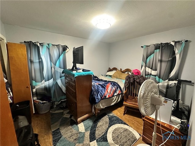 bedroom featuring hardwood / wood-style floors and a textured ceiling