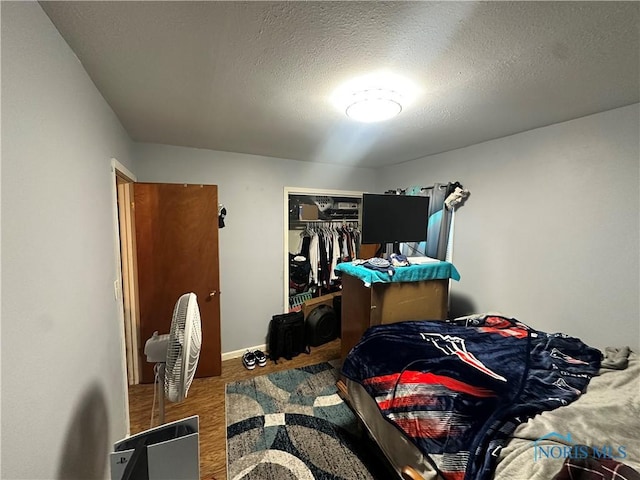 bedroom featuring a closet, a textured ceiling, and hardwood / wood-style flooring