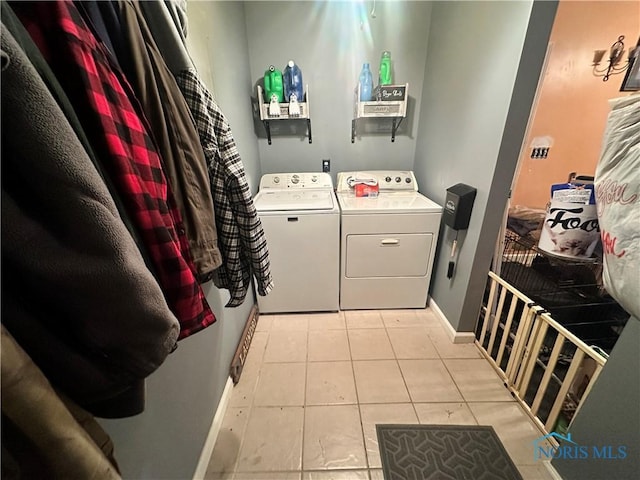 laundry area featuring light tile patterned floors and washer and dryer