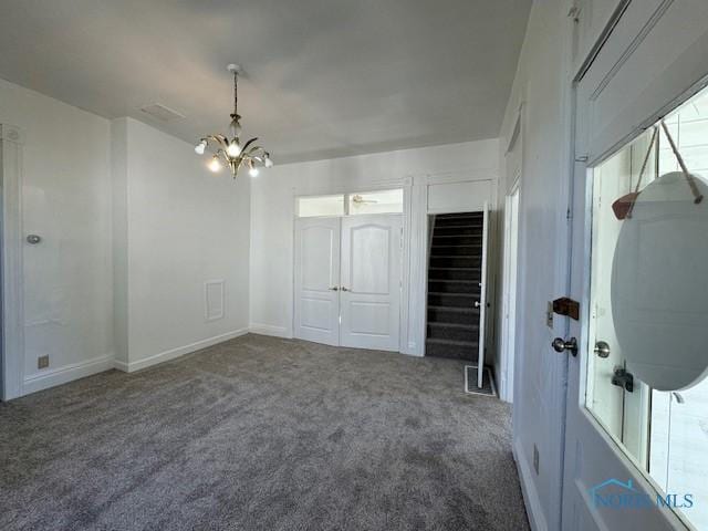 unfurnished room with a notable chandelier, carpet floors, and a wealth of natural light