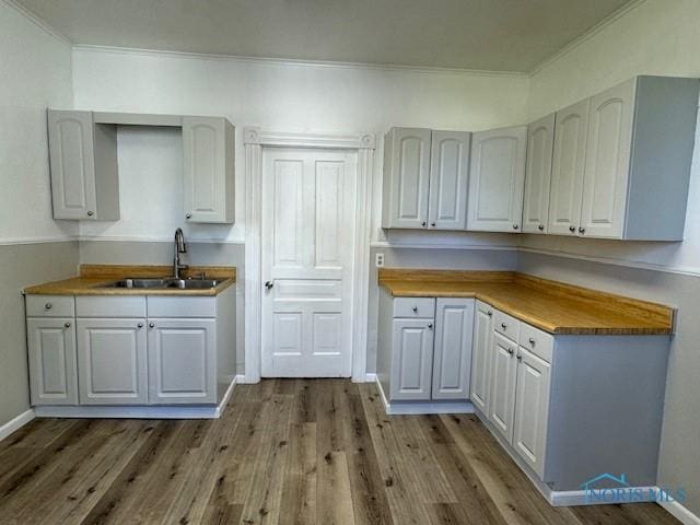 kitchen with dark hardwood / wood-style floors, crown molding, butcher block counters, and sink