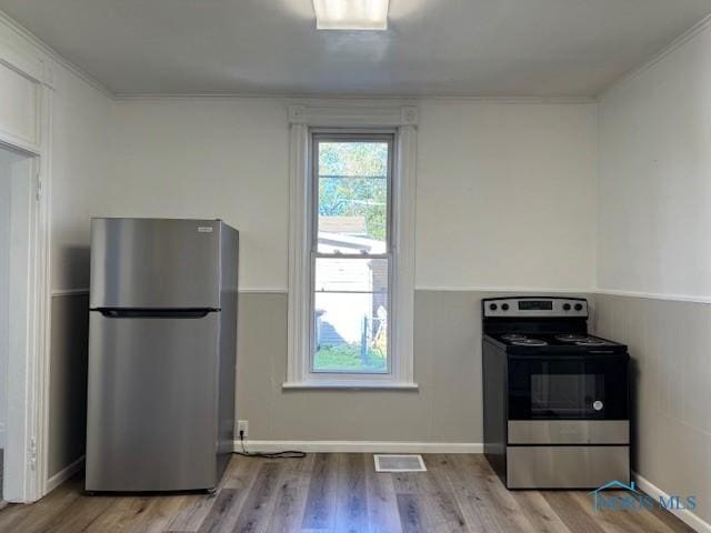 kitchen with light hardwood / wood-style floors and appliances with stainless steel finishes