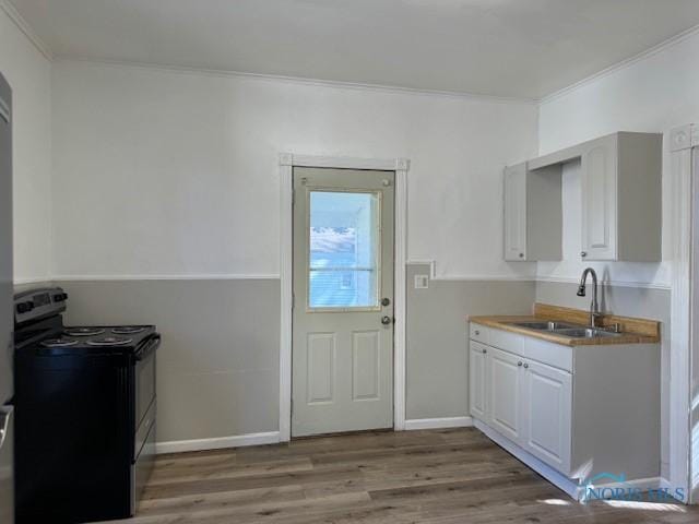 kitchen featuring electric range, white cabinetry, sink, and ornamental molding