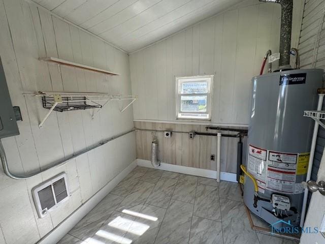 laundry room with wooden walls and gas water heater