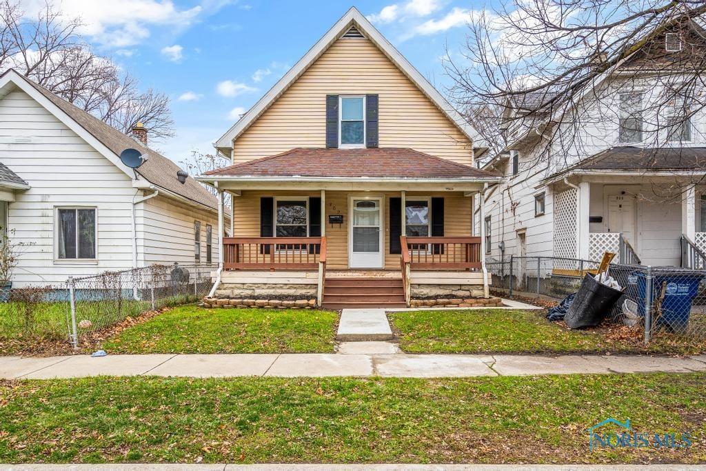 bungalow with covered porch and a front lawn