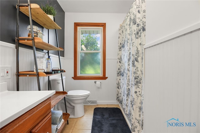 bathroom with toilet, vanity, tile patterned floors, and a shower with shower curtain