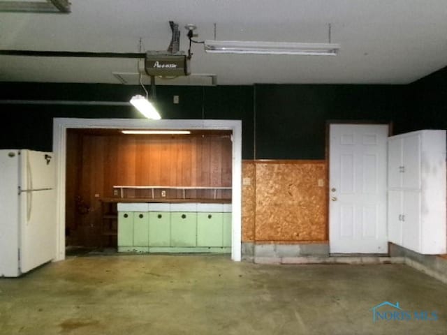 garage with white refrigerator and a garage door opener