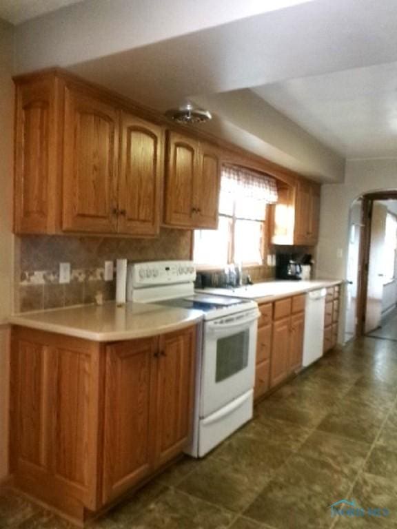 kitchen featuring white appliances and backsplash