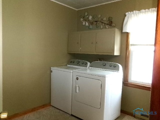 clothes washing area featuring cabinets and independent washer and dryer