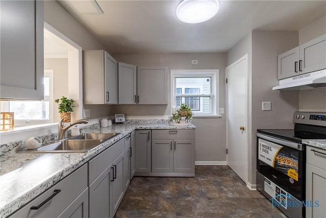 kitchen featuring electric range, light stone counters, gray cabinetry, and sink