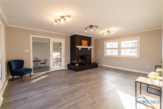 living room with hardwood / wood-style flooring, crown molding, and a fireplace