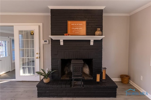 details featuring hardwood / wood-style floors, crown molding, and a brick fireplace