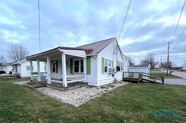 view of side of property with a lawn, cooling unit, and covered porch