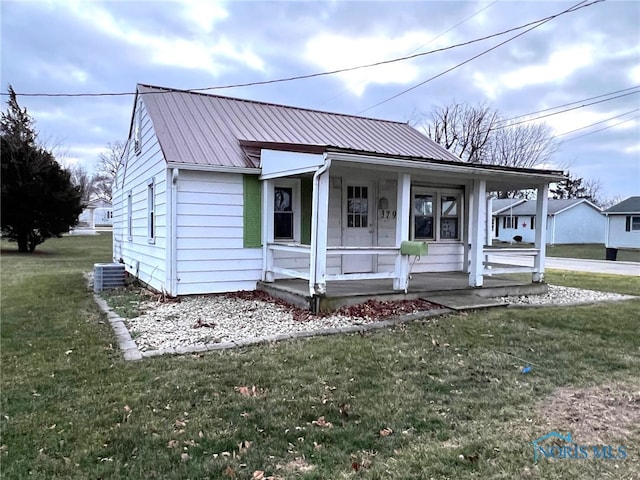 view of front of house featuring central AC unit, covered porch, and a front lawn