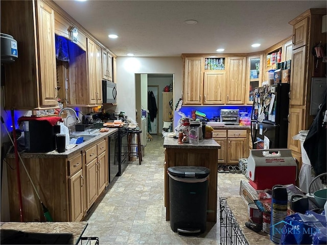 kitchen with sink, a kitchen island, and black appliances