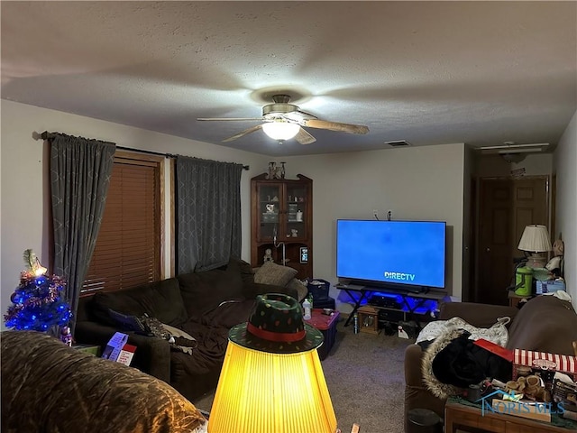 living room featuring ceiling fan, carpet floors, and a textured ceiling