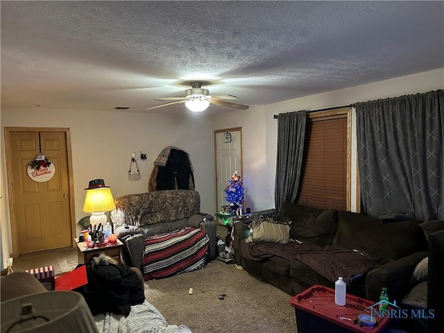 carpeted living room with ceiling fan and a textured ceiling